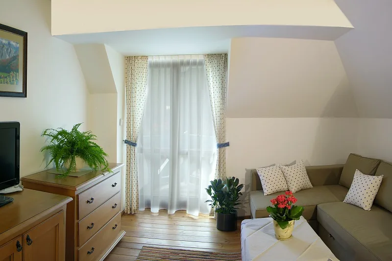 Izba s pohovkou, komodou a dverami na balkón